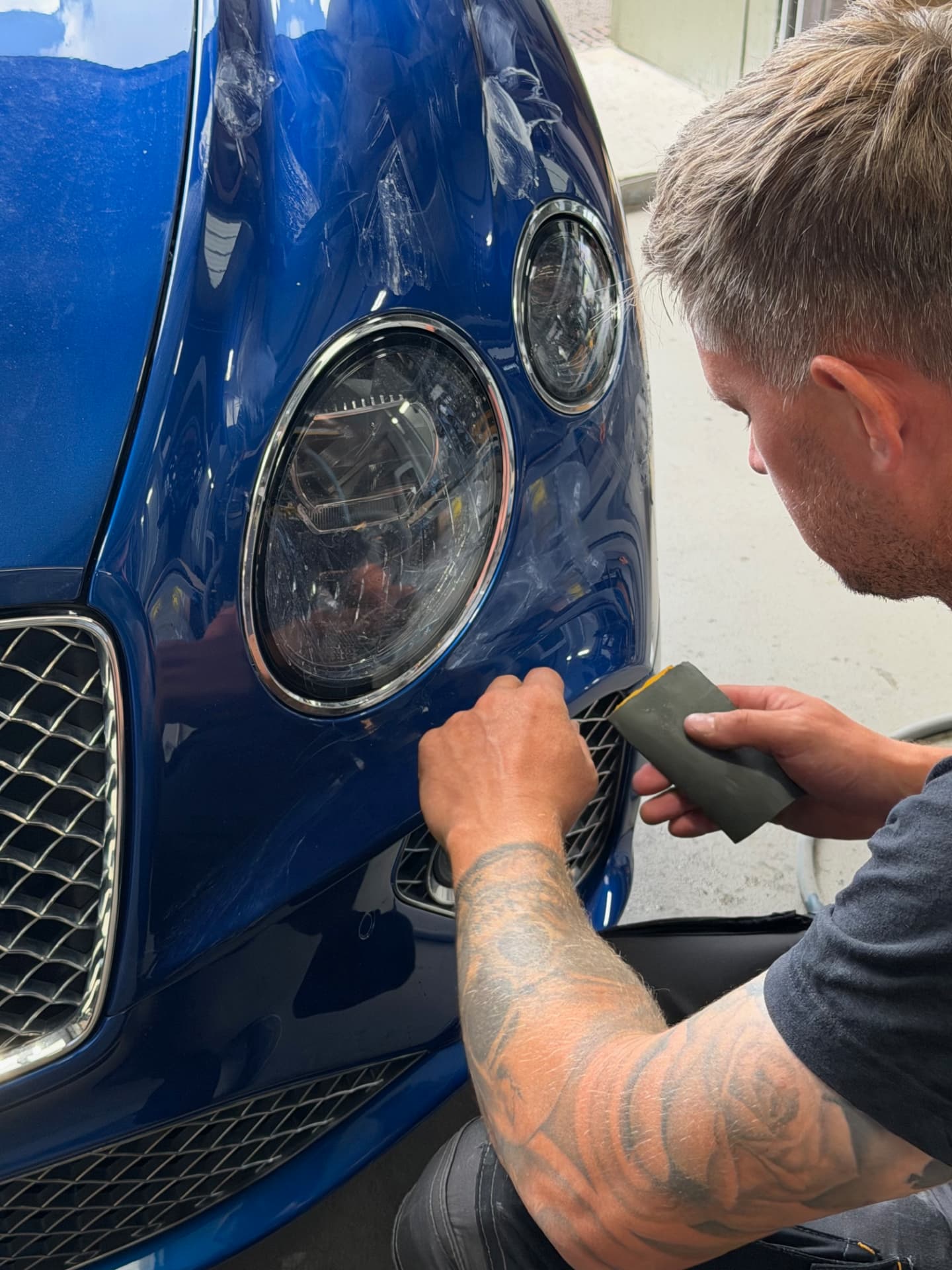 Technician hand-finishing paintwork at the Rocket Re-Finishing workshop